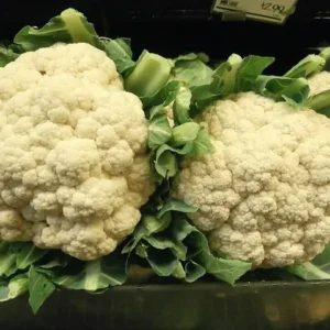 Two white cauliflowers with green leaves