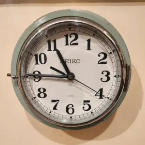 A round wall clock with a white face