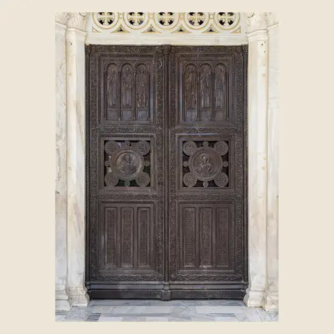A tall dark wooden door in a stone frame