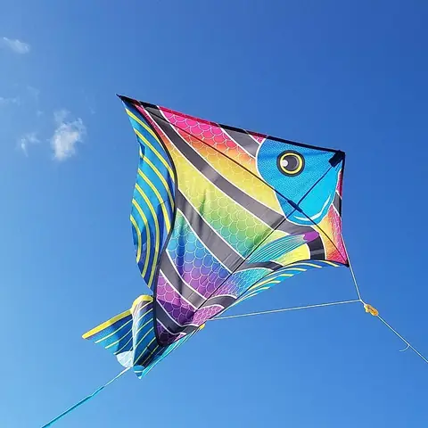 A colourful diamond-shaped kite in a blue sky