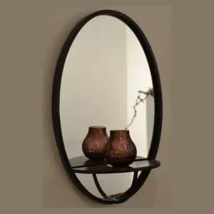An oval mirror with a dark frame on a wall