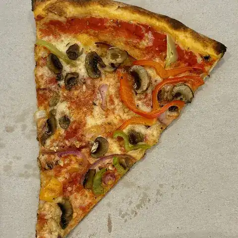 A single triangle slice of vegetable pizza