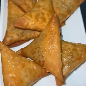 Golden triangle-shaped samosas on a plate