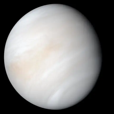 Pale yellow-white planet Venus covered in clouds